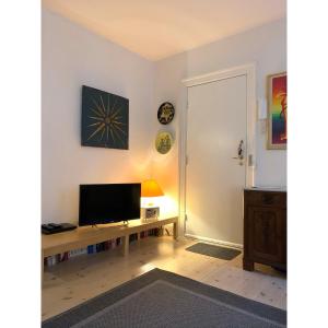 a room with a desk with a television on a wall at ApartmentInCopenhagen Apartment 200 in Copenhagen