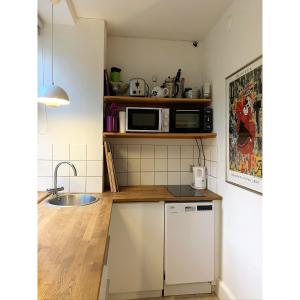 una pequeña cocina con fregadero y microondas en ApartmentInCopenhagen Apartment 200, en Copenhague