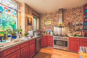 a kitchen with red cabinets and a brick wall at Buky Palace in Pons