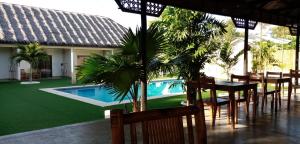 a patio with a table and chairs and a swimming pool at HIGALA Resort in Panglao Island