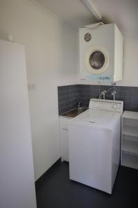 a small kitchen with a washing machine and a sink at Edlin House in Bright