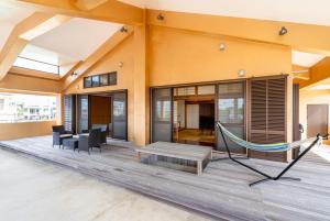 una hamaca en la terraza de una casa en HOLIDAY INN GARAKUTA, en Ishigaki Island