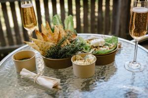 a table with a plate of food and glasses of wine at Fairways Resort in Rosebud