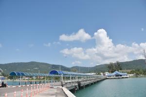 a bridge over a body of water with mountains in the background at Stay Inn Nathon Samui in Nathon