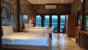 a hotel room with two beds and a balcony at Chiang Klong Riverside Resort in Chiang Khan