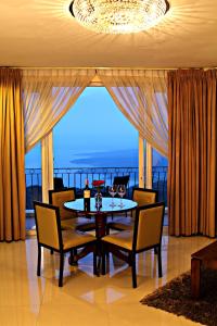 une salle à manger avec une table, des chaises et une grande fenêtre dans l'établissement The Lake Hotel Tagaytay, à Tagaytay