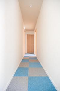 an empty hallway with blue and white floors at Osaka Guesthouse SAYURI TENGACHAYA Ekimae in Osaka
