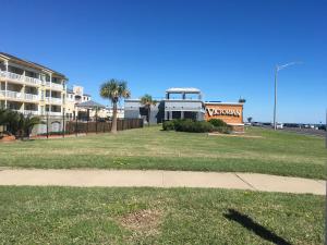 a grassy area with a building in the background at The Victorian Condo/Hotel in Galveston