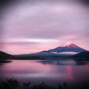 een berg die reflecteert in een meer bij zonsondergang bij K's House MtFuji -ケイズハウスMt富士- Travelers Hostel- Lake Kawaguchiko in Fujikawaguchiko