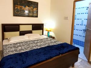 a bedroom with a bed with a blue comforter at Aditya Premium HomeStay- Furnished Air Conditioned- 2BHK in Jabalpur