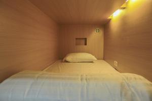 a small bedroom with a bed in the corner at Petit Espace Boutique Hostel in Vientiane