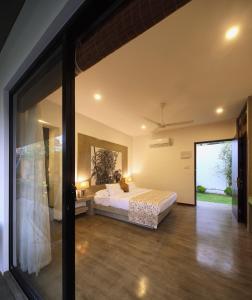 a bedroom with a bed and a large window at Serendiva Beach in Wadduwa