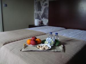 een dienblad met fruit- en waterflessen op een bed bij Casa da Ermida in Velas