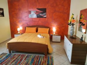 1 dormitorio con 1 cama con pared de color naranja en B&B Salerno, en Sarno