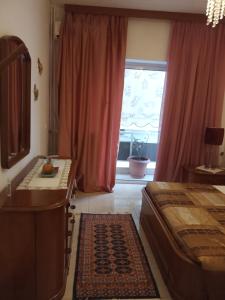 um quarto com uma cama, uma mesa e uma janela em Maria 's home em Heraclião