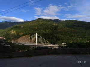 a white bridge on a hill with a mountain at 知本喻禾溫泉民宿 in Wenquan