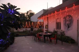 a patio with a table and chairs and christmas lights at The Desire Hostel in New Delhi