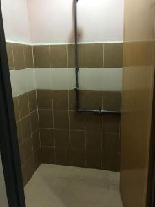 a bathroom with a shower with brown and white tiles at langkawi homestay murah kawasan bandar in Kuah