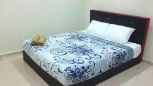 a bed with a blue and white comforter with a purse on it at langkawi homestay murah kawasan bandar in Kuah