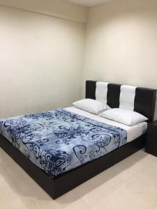 a bedroom with a bed with a blue and white blanket at langkawi homestay murah kawasan bandar in Kuah