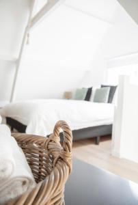 a bedroom with a bed and a basket at Tiny House Lindenhouse in Heemstede