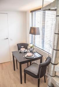 a dining room table with two chairs and a lamp at Tiny House Lindenhouse in Heemstede