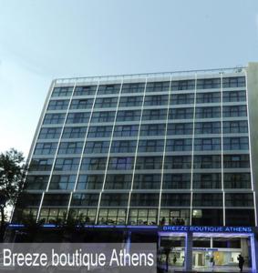 duży budynek z znakiem przed nim w obiekcie Breeze Boutique Athens w Atenach