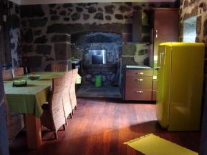 a kitchen with a table with chairs and a refrigerator at Casa da Ermida in Velas +17 photos
