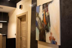 ein Gemälde, das an einer Wand neben einer Tür hängt in der Unterkunft Hotel Elements in Novi Pazar