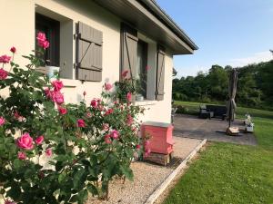 a house with pink roses in the yard at Domaine de La Charmille in Ermenonville