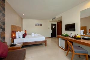 um quarto de hotel com uma cama e uma secretária em Baramee Resortel em Praia de Patong