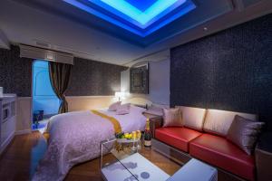 een slaapkamer met een bed en een rode bank bij HOTEL W-AVANZA-W GROUP HOTELS and RESORTS- in Chiba