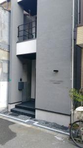 a white building with a door on the side of it at CASA Higashi Mikuni 02 in Osaka