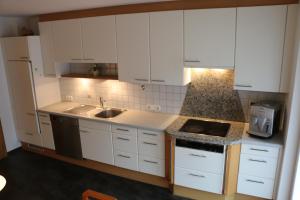 a kitchen with white cabinets and a sink at Gästehaus Schoder in Vandans