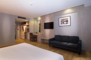 une chambre d'hôtel avec un lit et un canapé dans l'établissement Baan Karon Resort, à Karon Beach