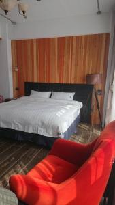 - une chambre avec un lit et une chaise rouge dans l'établissement Mr. Buster B&B, à Hualien