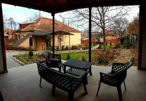 a patio with a table and chairs and a house at Slovac House with a garden and fireplace in Chişinău