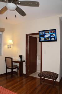 een woonkamer met een tafel en een tv aan de muur bij Hotel Plaza Chihuahua in Chihuahua