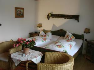 a room with a bed and two chairs and a table at Hotel Zur Erholung in Braunlage