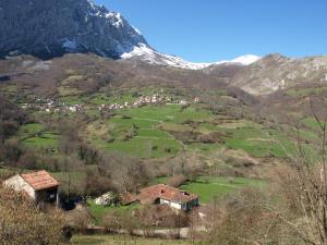a small village on a hill with a snow covered mountain at La Currada in Taranes
