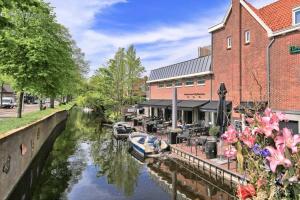 a river with boats docked in front of a building at Tiny House Lindenhouse in Heemstede