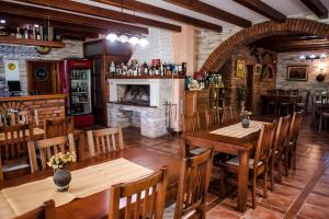 a restaurant with wooden tables and chairs and a fireplace at Villa Monako 2000 in Međugorje