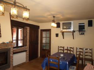 a dining room with a table and a tv at La Currada in Taranes
