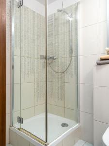 a shower with a glass door in a bathroom at Nozownicza Street Apartment in Wrocław