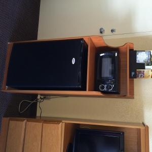 a microwave and a television on top of a cabinet at Whitten Inn University in Abilene