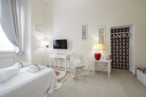 a white bedroom with two beds and a table and chairs at Milcovich Suites in Barletta