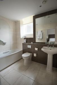 a bathroom with a tub and a toilet and a sink at Macdonald Old England Hotel & Spa in Bowness-on-Windermere