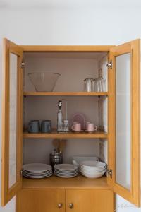 a wooden cabinet with plates and dishes in it at Casa Gnostra in Noci