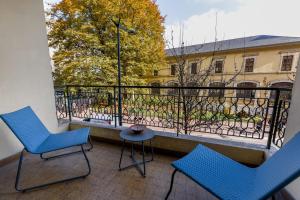 Duas cadeiras e uma mesa numa varanda com vista para um edifício em Appartement 2 chambres au coeur d'Annecy avec terrasse em Annecy