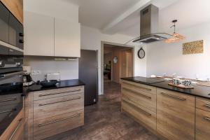 a kitchen with wooden cabinets and a black counter top at Appartement 2 chambres au coeur d'Annecy avec terrasse in Annecy
